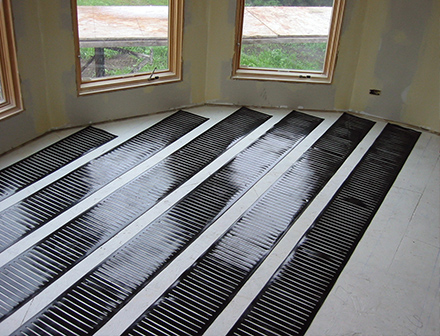 Radiant floor heating system being installed in family room.